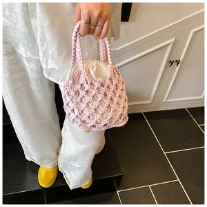 Détail du sac seau crocheté à la main rose avec une pochette intérieure à cordon blanc