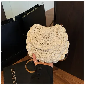 Détail du sac à bandoulière en crochet crème avec motifs ondulés et lanière en cuir