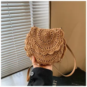 Gros plan détaillé du crochet en forme d'éventail du sac bandoulière en paille kaki