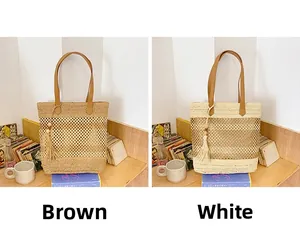 Detail of woven straw tote bags in brown and beige with tassels and leather handles