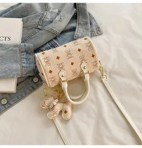 Detail of Boston handbag with teddy bear print, gold hardware and cute bear charm