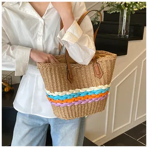Dettaglio di strisce color arcobaleno su una borsa tote in paglia con manici in pelle