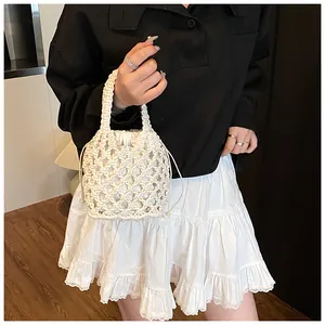 Détail du sac tricoté main crème montrant la maille losange et la doublure à cordon