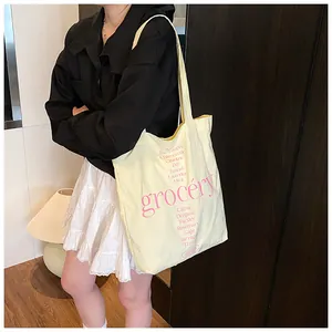 Detalle de la bolsa tote de lona amarilla clara con estampado botánico rosa y correa
