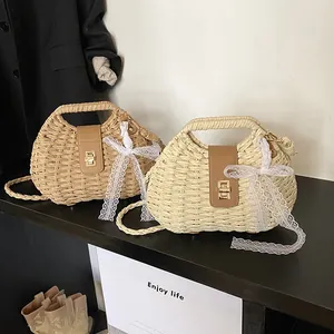 Straw woven crossbody bag with shell shape, metal twist lock and white lace ribbon detail
