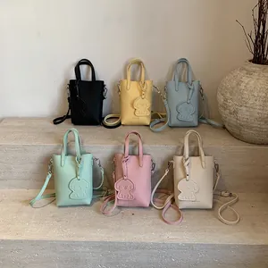 Mini borsa tote texture litchi in sei colori con tracolla e ciondolo a forma di cane