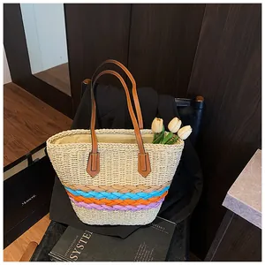 Dettaglio borsa tote in paglia a righe arcobaleno con manici in pelle marrone