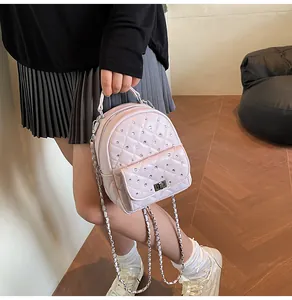 Detailed view of pink quilted mini backpack featuring crystal studs and silver twist lock
