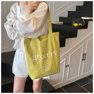 Detalle del bolso tote de lona con estampado de hierbas y textura en amarillo mostaza