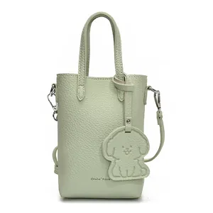 Mini borsa a tracolla verde fagiolo con trama litchi e ciondolo a forma di cane