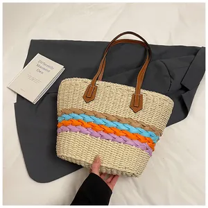 Dettaglio della borsa tote in paglia a righe arcobaleno con manici in pelle marrone
