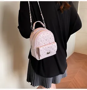 Detail of pink quilted mini backpack with silver studs and metal chain straps