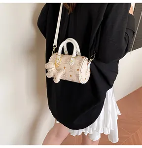Mini white Boston bag with bear print and charm, crossbody view on model with white strap