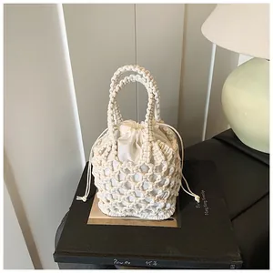 Détail du sac seau tissé à la main en crème avec maille évidée et doublure à cordon