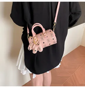 Pink Boston mini bag with bear print and cute charm shown in a cross-body lifestyle view