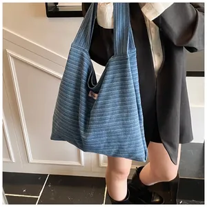 Close-up of blue striped canvas tote bag showing soft knit texture and pink side label