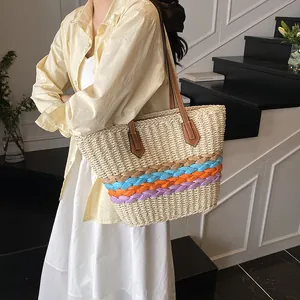 Borsa tote in paglia a righe arcobaleno con manici in pelle indossata da una modella in scena