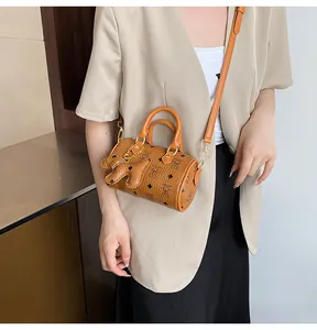 Detail of a brown Boston bag with cartoon rabbit prints and a matching charm accessory
