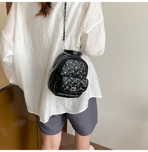 Detail view of black quilted mini backpack with rhinestone studs and chain shoulder straps
