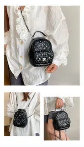 Detail of black quilted mini backpack with silver rivets and leather chain straps