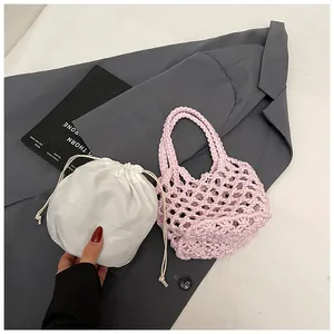 Détail d'un sac à main en tricot rose avec pochette intérieure blanche à cordon et maille ajourée