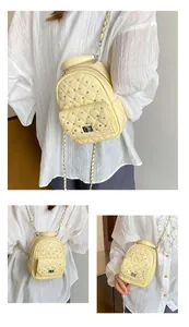 Close-up of yellow quilted mini backpack with rhinestone details and silver chain strap