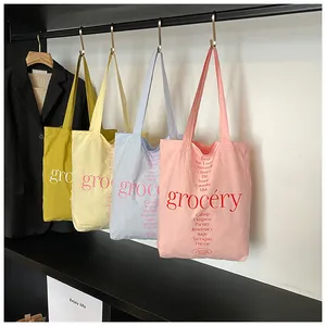Detalle de cuatro bolsas de lona de colores con estampado de grocery y plantas de hierbas