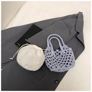 Gros plan détaillé d'un sac cabas en maille lilas avec une pochette intérieure blanche