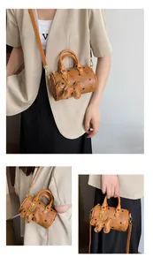 Detail of a brown mini Boston bag with vintage monogram and cute puppy charm
