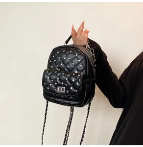 Detailed close-up of mini quilted backpack with sparkling crystal studs and chain strap