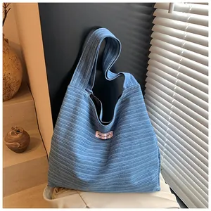 Detail view of sky blue corduroy tote bag featuring pink Have a Nice Day label
