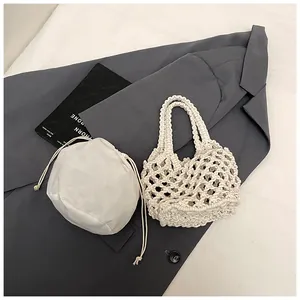 Sac à main blanc tressé à la main avec pochette intérieure sur blazer anthracite