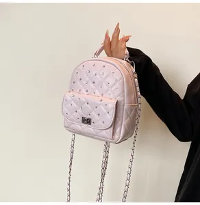 Detail of pink quilted mini backpack with rhinestone studs and silver twist lock