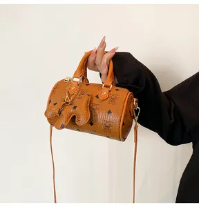 Detailed shot of brown Boston bag with cartoon bear prints and golden metal hardware