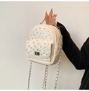 Detail of quilted leather mini backpack with silver turn-lock and chain strap