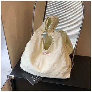 Close-up of cream canvas tote bag with textured star jacquard and pink label patch
