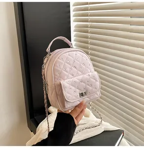 Detailed view of pale pink quilted mini backpack with rhinestone accents and silver twist lock