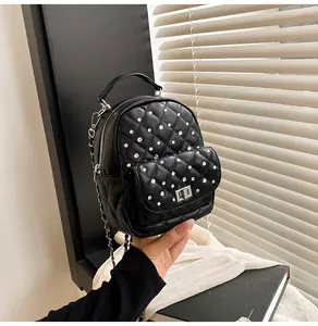 Close-up of black quilted mini backpack with rhinestone studs and metal twist lock