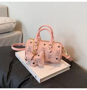 Detail of pink Boston bag with cartoon bear print and leather dog-shaped charm