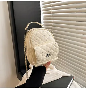 Detail of cream mini backpack with quilted pattern, rhinestones and silver chain strap