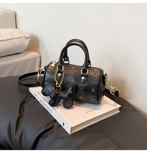 Detail of black cylinder bag with rabbit print, lizard texture and gold hardware