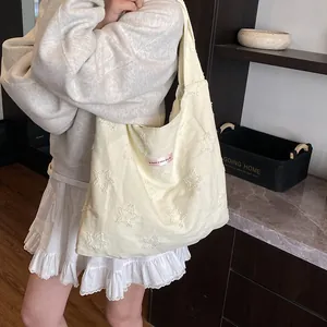 Fashionable creamy yellow canvas tote bag with 3D embossed star patterns and pink tag