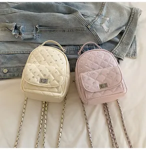 Close-up of quilted mini backpacks with rhinestone accents and metal chain straps