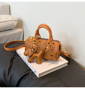 Detail of retro brown Boston bag with cartoon bear prints and dog-shaped leather charm
