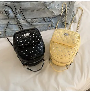 Close-up of mini quilted chain backpacks in black and yellow with rhinestone accents
