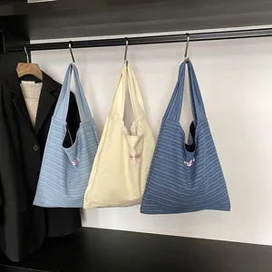 Three minimalist canvas tote bags with summer stripes and embossed stars on hangers