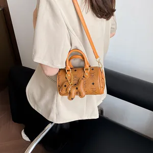Retro caramel Boston bag with patterned print and cute dog charm for a stylish look