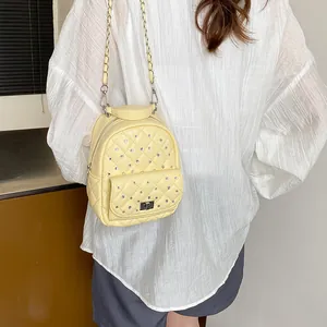 Quilted mini backpack with rhinestones and silver chain straps on model