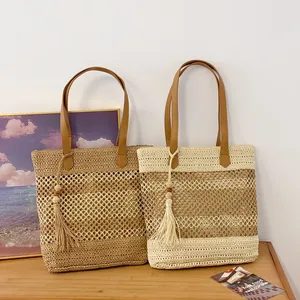 Hollow straw woven shoulder bags with leather straps and tassels in bohemian beach style