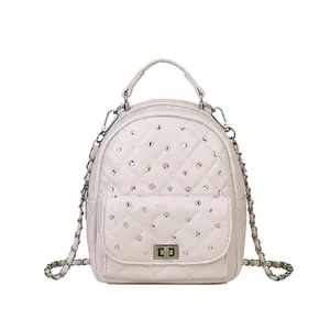 Pink quilted backpack with rhinestones and silver metal chain straps on white background
